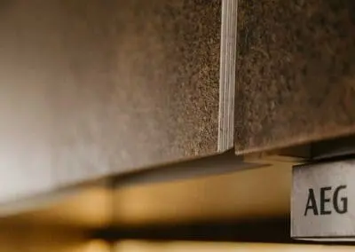 A close-up shot of a kitchen door front with a shadow gap handle. The substrate is birch ply but an oak lip has been added. The front is made from Husk Kava surface.